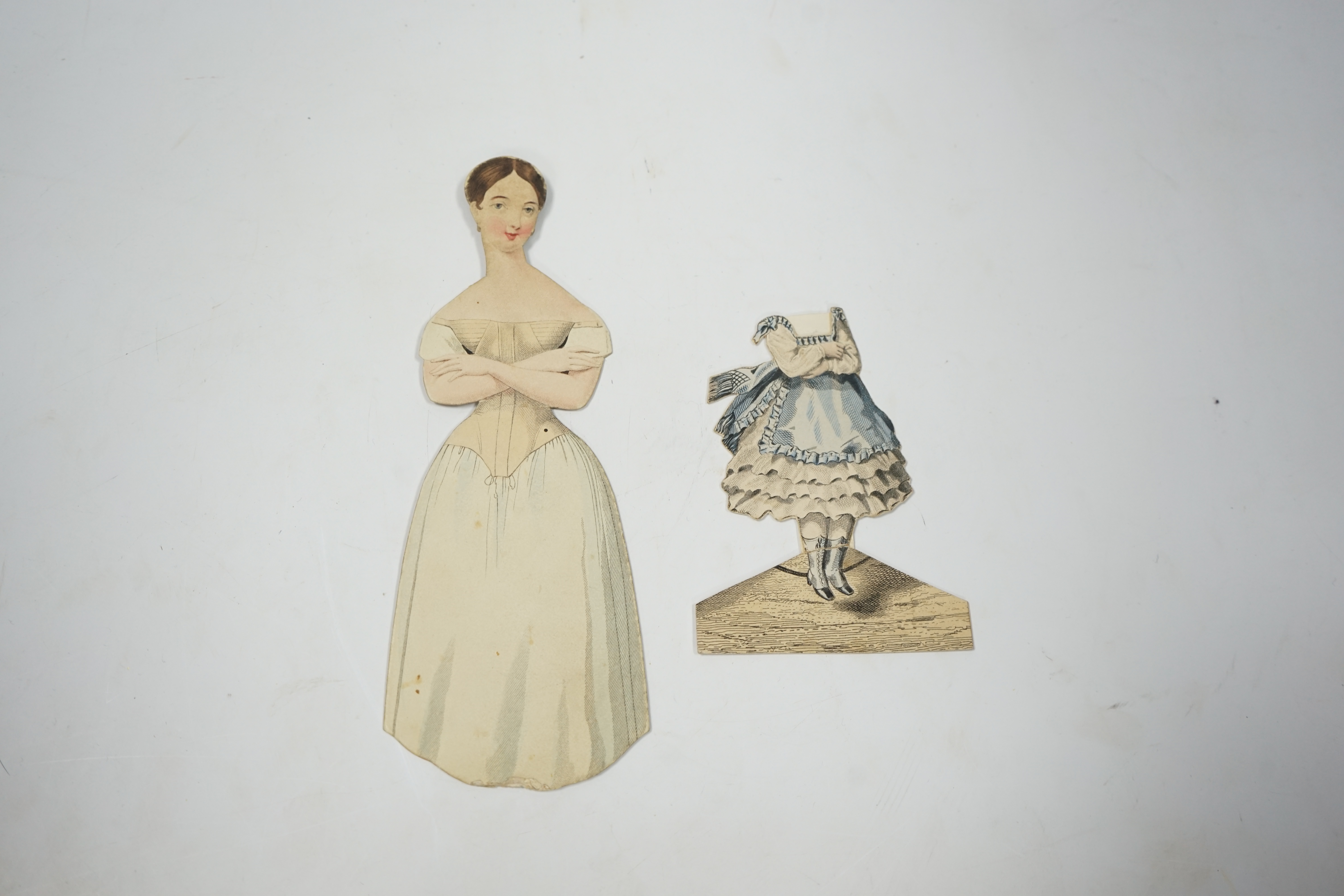 An early 19th century boxed Rudolph Ackermann La Poupee-Modele paper doll set, comprising of a double sided doll in lingerie with mahogany stand, six double sided gowns and four bonnets, together with eight similar figur